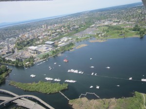 Boats lining up for front & center view of the crew races. Husky Stadium, in the midst of remodeling, is in the background